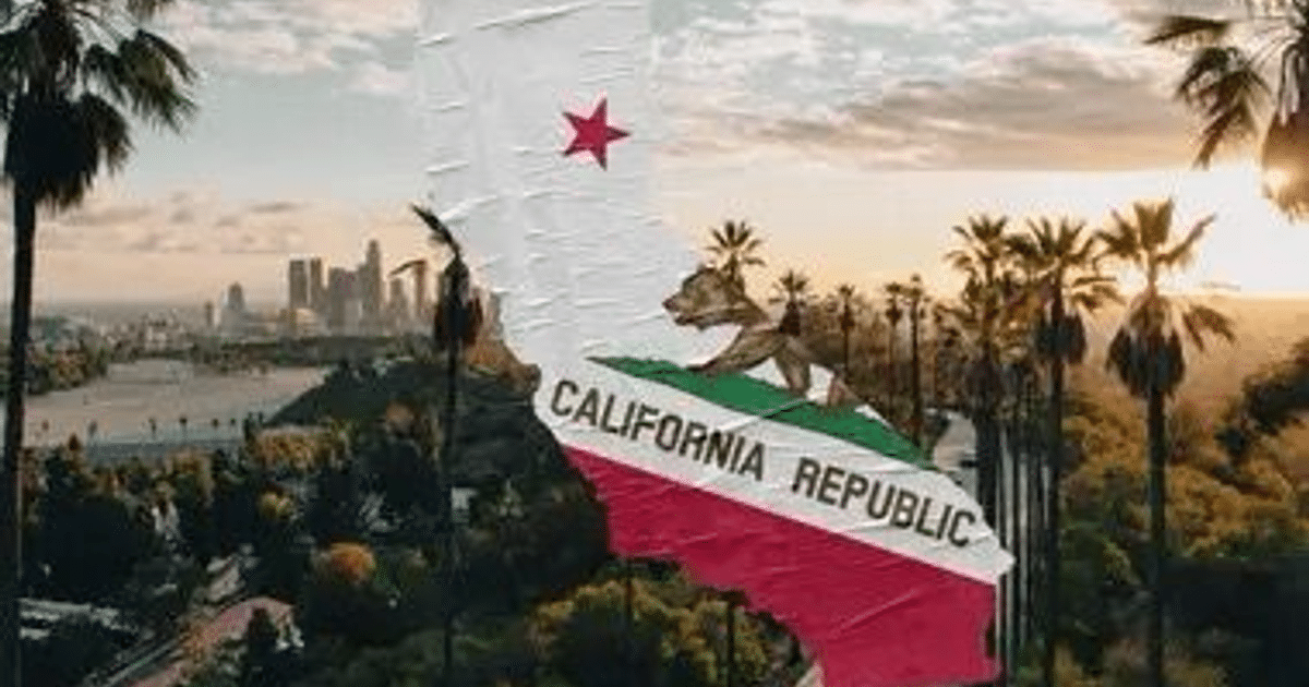 Vista urbana de California con palmeras, río, edificios y la bandera estatal al atardecer.