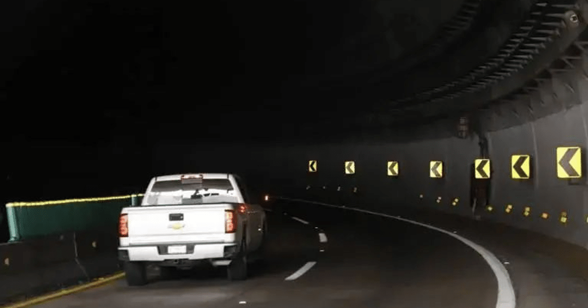 Camioneta blanca en túnel oscuro con señales de advertencia en Mazatlán-Durango