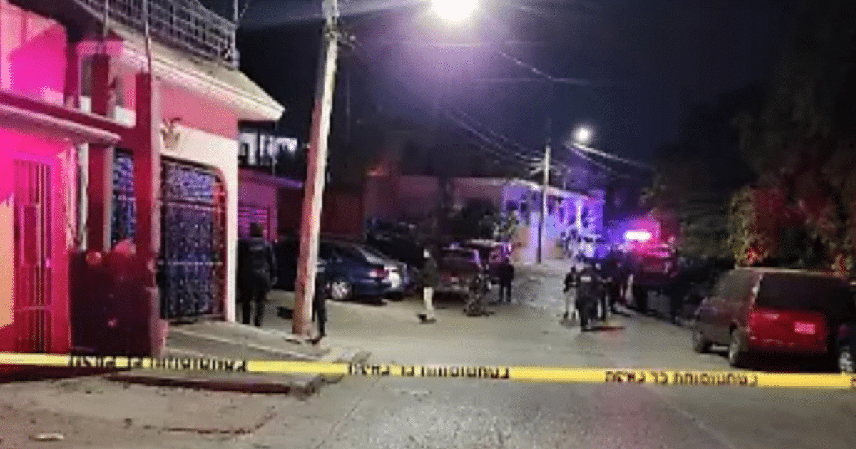Calle nocturna en Culiacán con vehículos policiales y cinta de advertencia tras tiroteo.