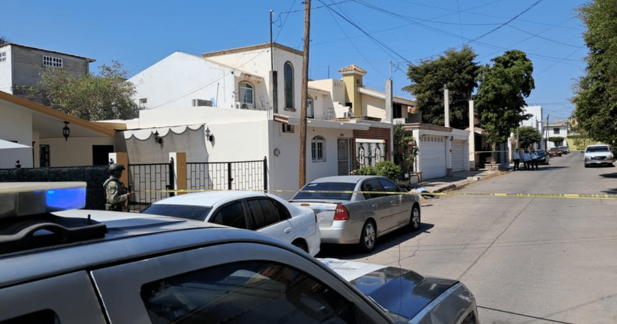 Calle en Culiacán con vehículo, agente de seguridad y cinta de precaución