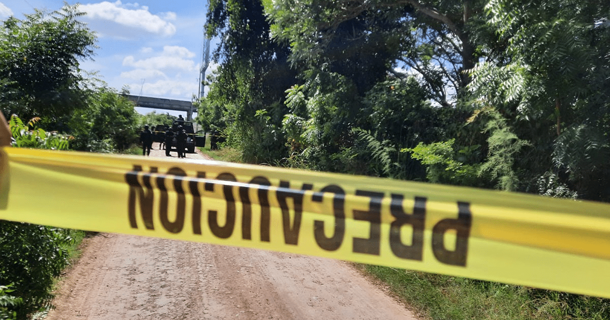 Camino con cinta de precaución y vehículos de seguridad en Culiacán