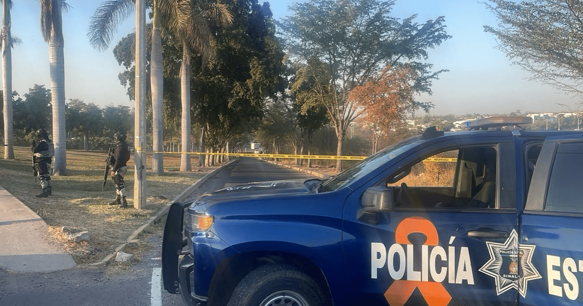 Operativo policial en Culiacán con vehículo azul, agentes armados y cinta amarilla de investigación.