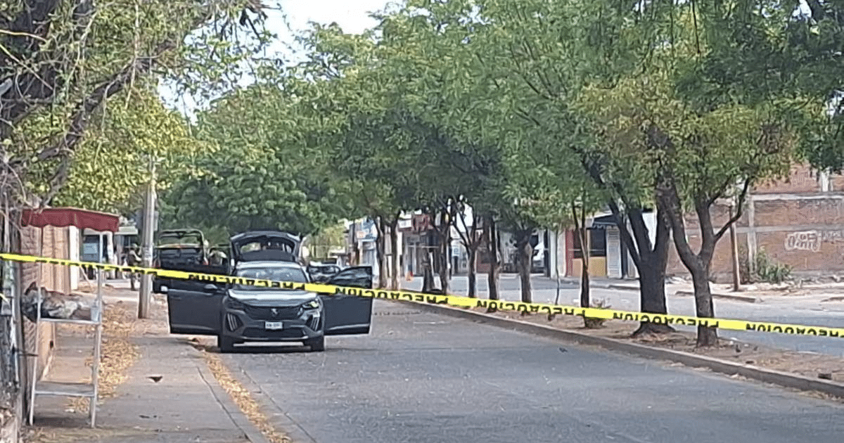 Calle en Culiacán con coche negro acordonado por cinta amarilla, relacionada con explosivos.