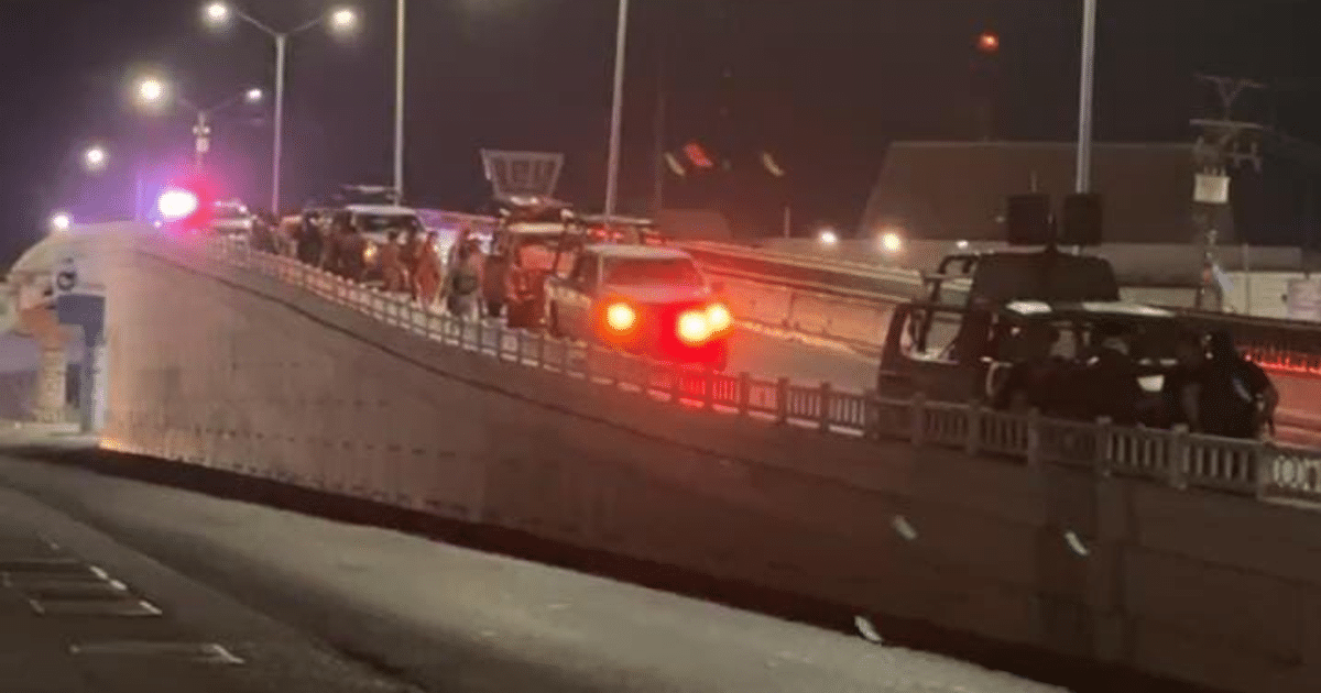 Operativo policial nocturno en Culiacán con vehículos y luces de emergencia en carretera elevada.