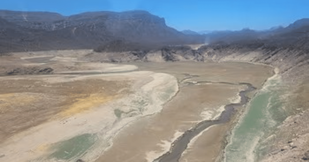 Lecho de río seco en Sinaloa con montañas al fondo, reflejando la sequía actual.
