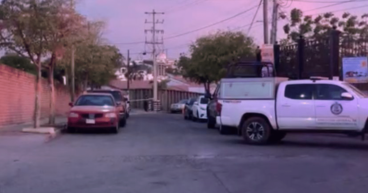 Calle urbana con vehículos estacionados y cielo rosado al atardecer