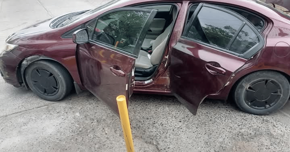 Automóvil púrpura oscuro con puertas abiertas en zona urbana