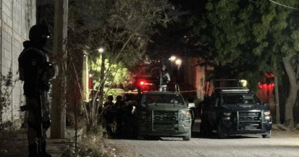 Operativo de seguridad nocturno con personal táctico y vehículos en terreno baldío.