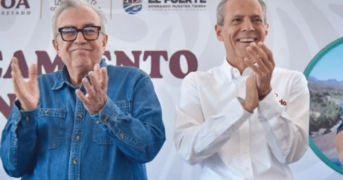Dos hombres aplaudiendo en un evento formal, uno con camisa azul y otro con camisa blanca, fondo con texto de presentación.