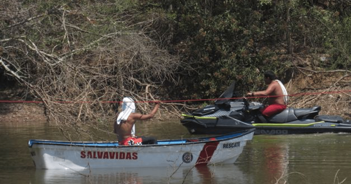 Dos hombres en un operativo de rescate acuático en la laguna de Sonterra, uno en una embarcación de rescate y otro en una moto de agua.