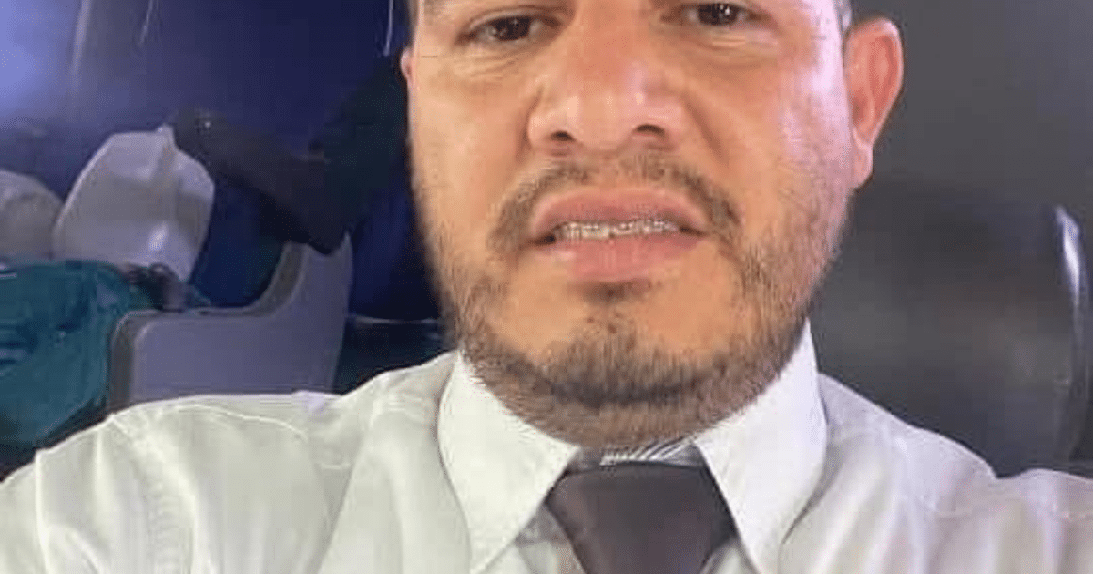 Autorretrato de Juan Carlos Miramontes en un autobús con camisa blanca y corbata