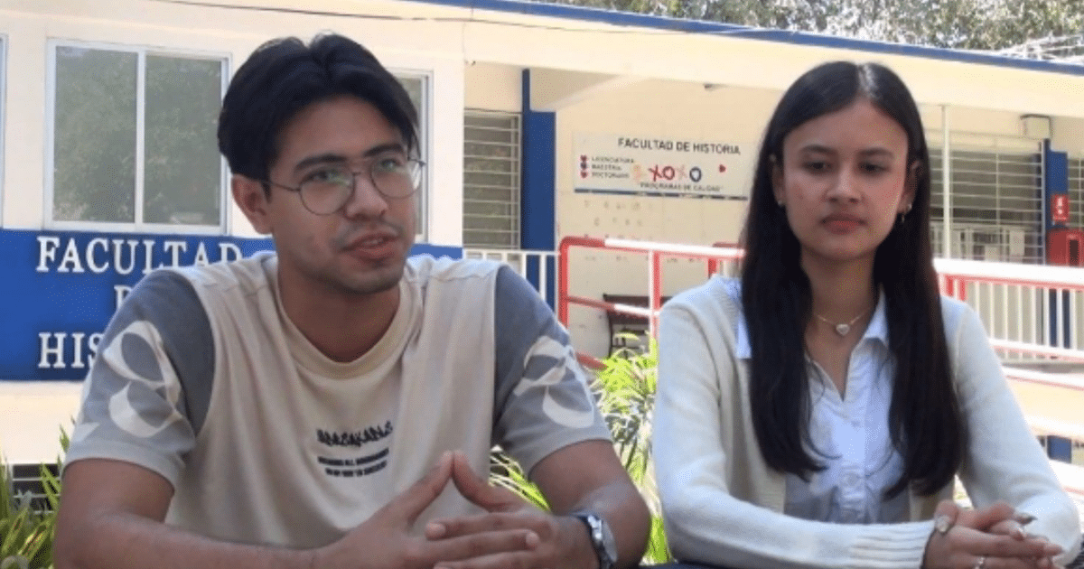 Dos estudiantes conversando frente a la Facultad de Historia de la Universidad Autónoma de Sinaloa.