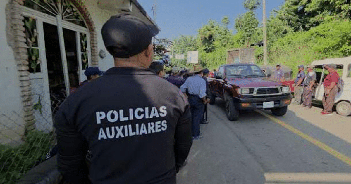 Grupo de personas en una calle con un policía auxiliar destacado, en un entorno rural de Tapachula.