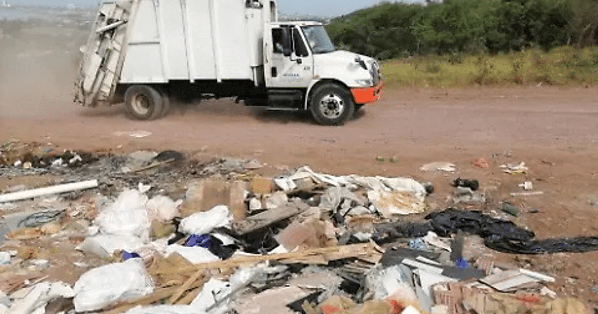 Camión de basura en camino de tierra cerca de desechos en Mazatlán