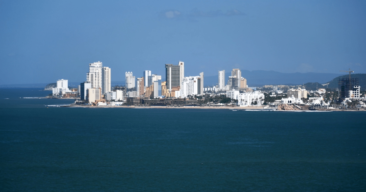 Vista panorámica de una costa urbana con edificios y playa, reflejando el auge inmobiliario en México.