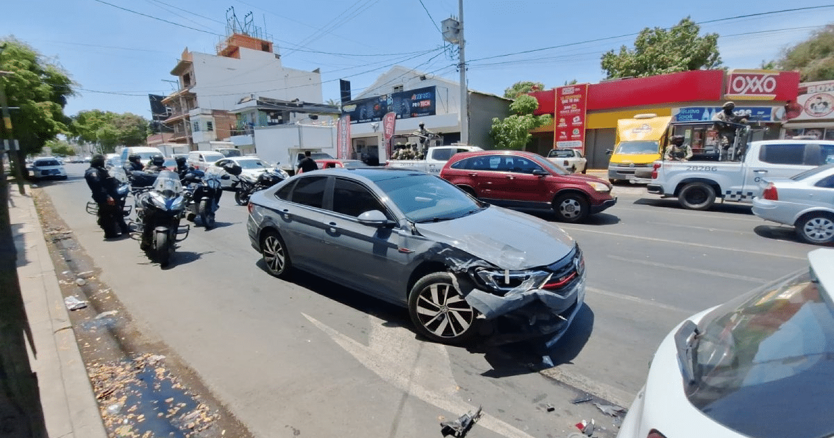 Automóvil gris dañado tras choque en Culiacán, con policías y vehículos alrededor.
