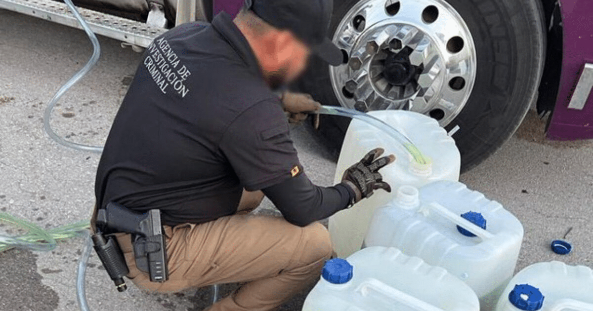 Agente de la Agencia de Investigación Criminal inspeccionando un camión en Durango por heroína líquida.