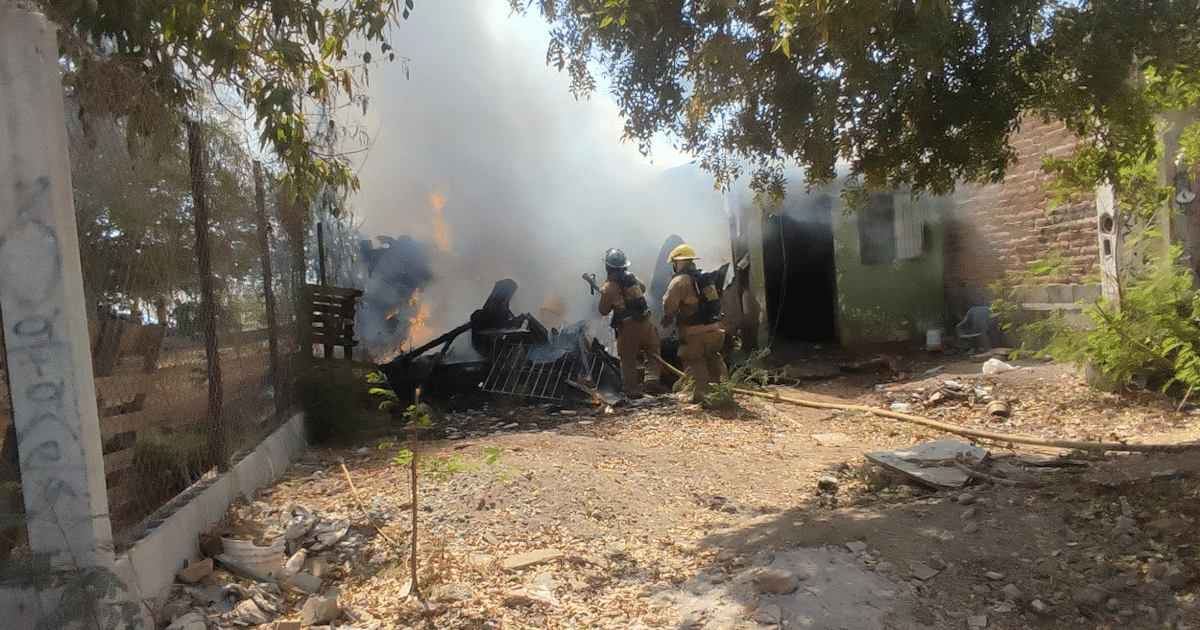 Bomberos combatiendo incendio en Los Mochis con llamas y humo en el fondo