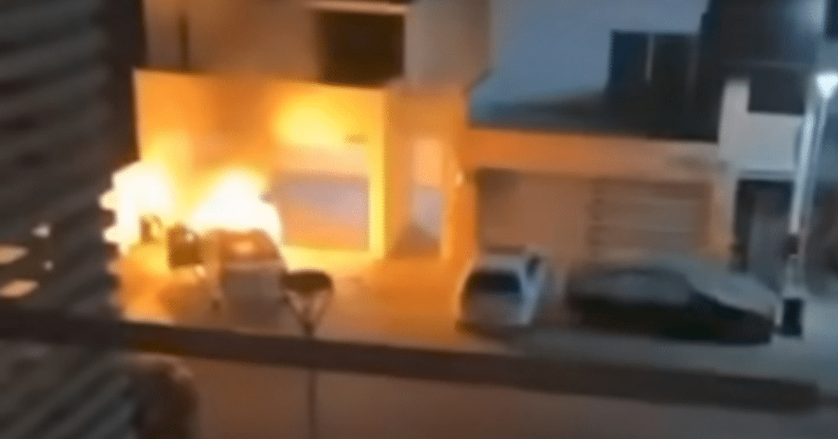 Incendio nocturno de vehículo en Culiacán, con llamas iluminando la calle y vehículos estacionados.