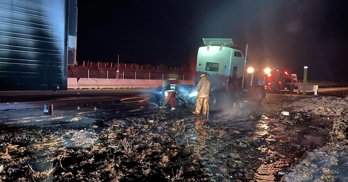 Bomberos atendiendo un incidente nocturno en la autopista Mazatlán-Culiacán con un camión emitiendo humo.