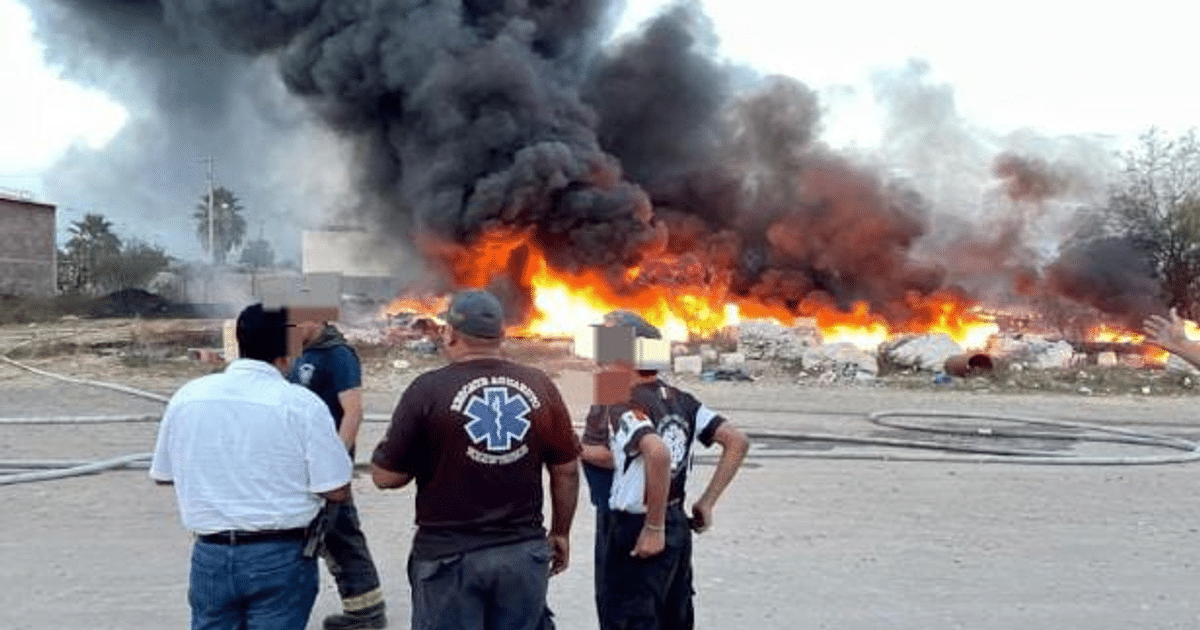 Incendio en Culiacán con humo negro y llamas, personas observando en primer plano