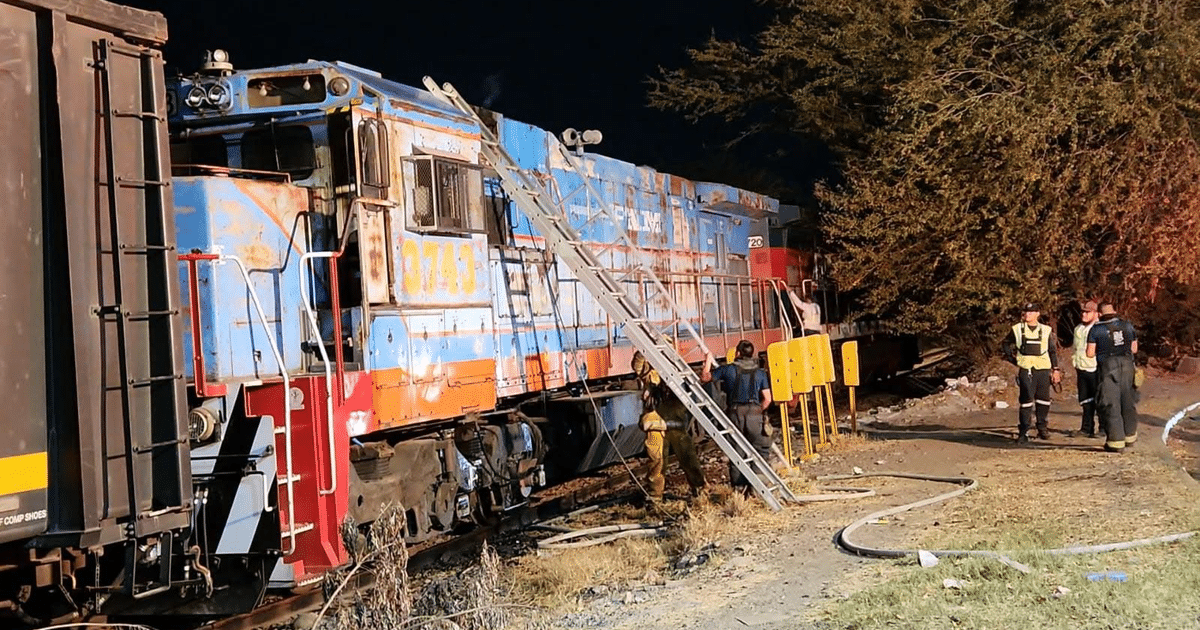 Tren de carga de Ferromex con trabajadores de emergencia en operación nocturna tras incendio en locomotora.