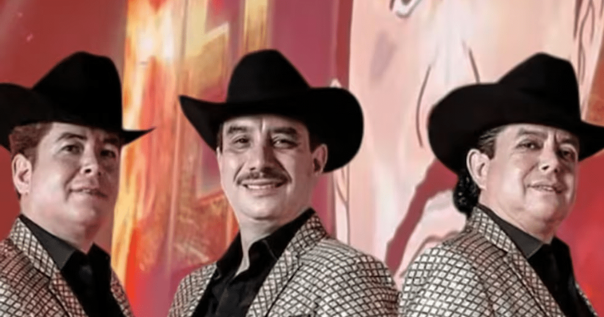 Tres hombres con chaquetas brillantes y sombreros posan sonrientes en un fondo colorido.