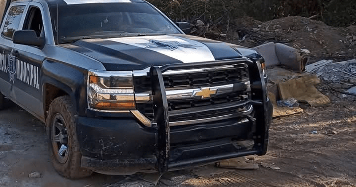Pickup de policía municipal en Mazatlán con escombros al fondo.