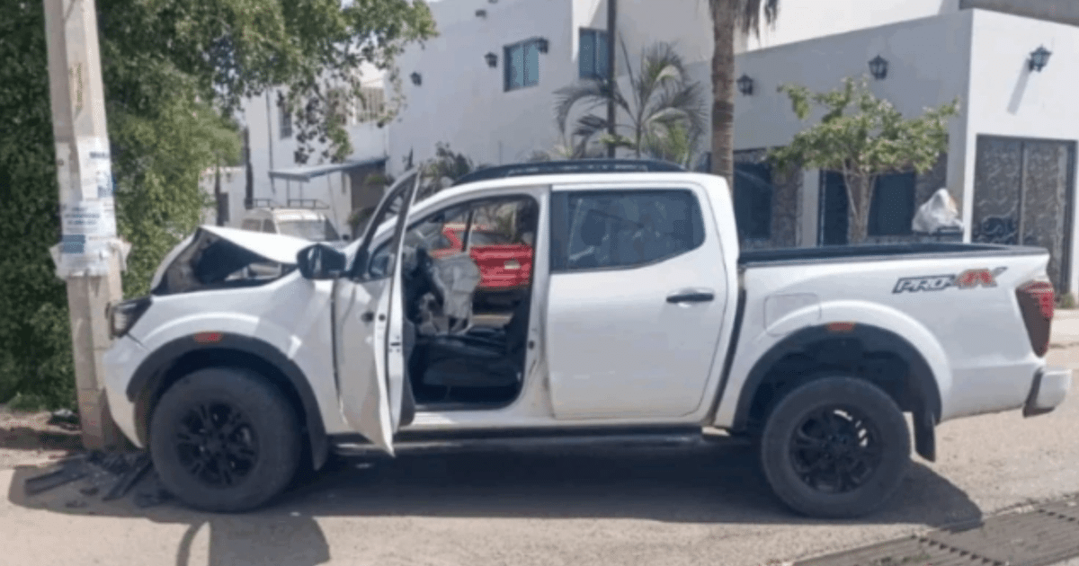 Camioneta blanca dañada tras accidente en Culiacán, con capó levantado y puerta abierta.