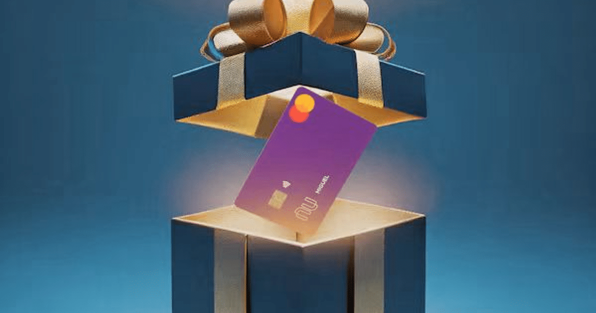 Caja de regalo abierta con tarjeta Mastercard púrpura y lazo dorado sobre fondo azul.