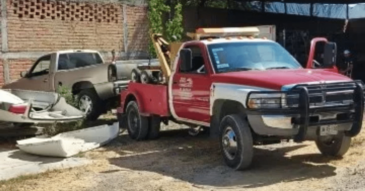 Grúa roja y blanca en un taller durante operativo policial en Jalisco