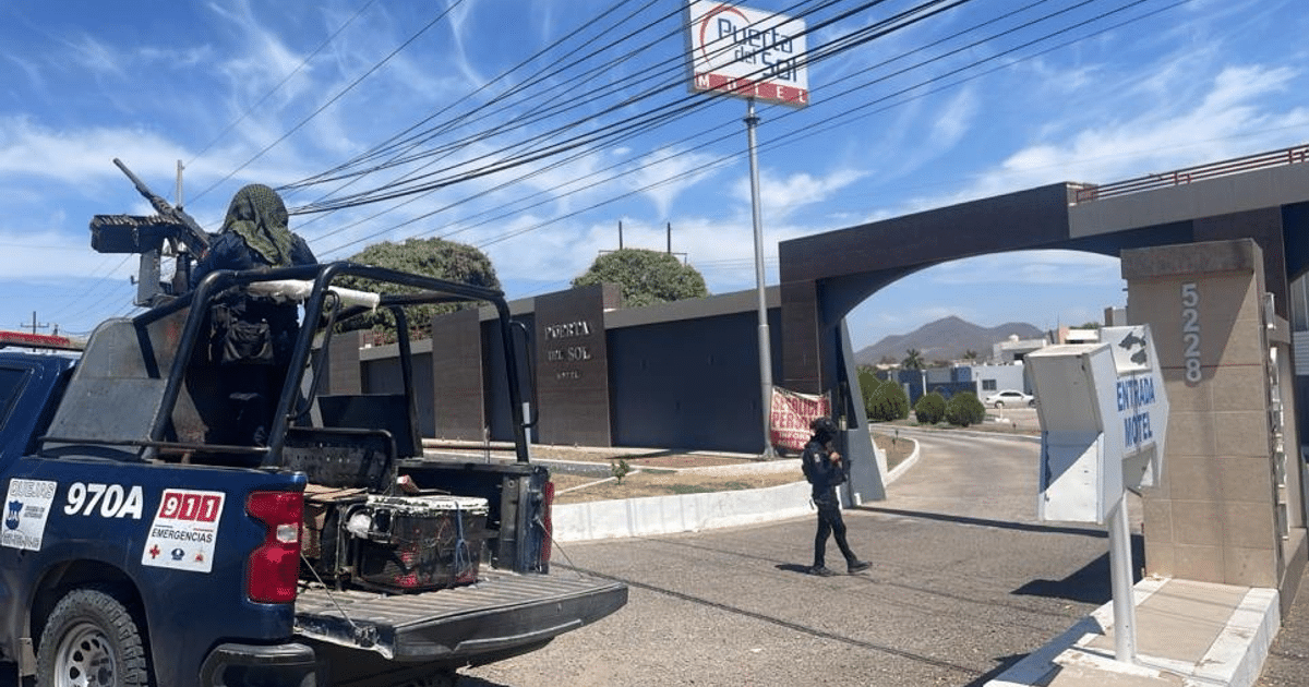 Operativo de rescate en motel Puerta del Sol, Culiacán, con vehículo policial y personal armado.
