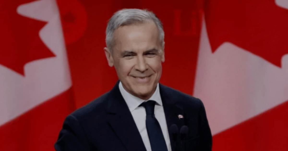Mark Carney sonriendo con banderas de Canadá de fondo tras victoria electoral