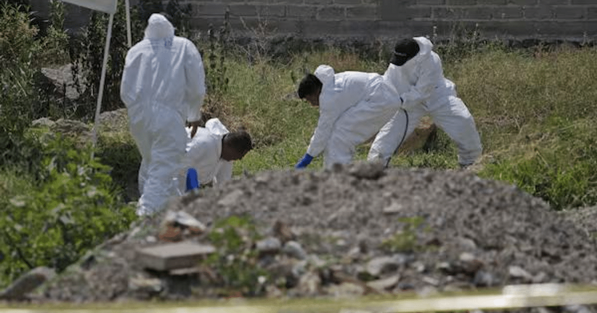 Equipo forense en trajes blancos investigando en un área exterior con escombros, relacionado con el hallazgo de restos humanos en Puebla.