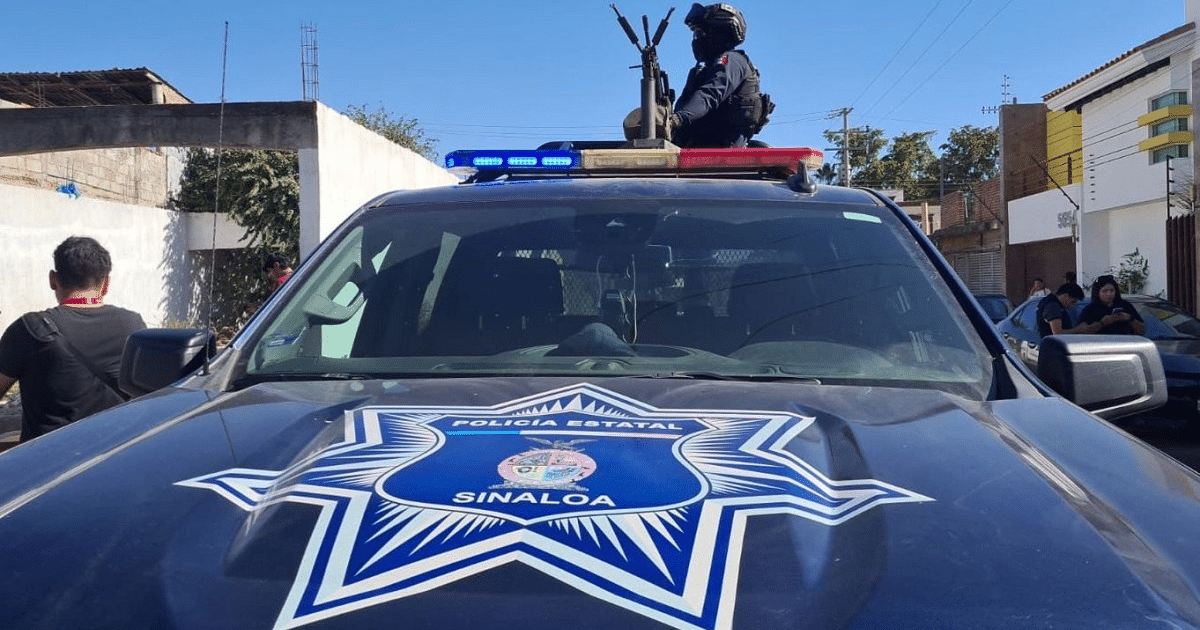 Camioneta policial de Sinaloa con oficial armado y luces de emergencia en entorno urbano