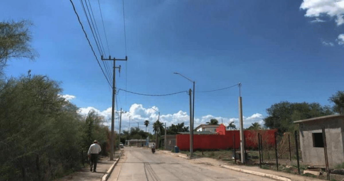 Calle tranquila en Saca de Agua con vegetación, casa y cielo azul