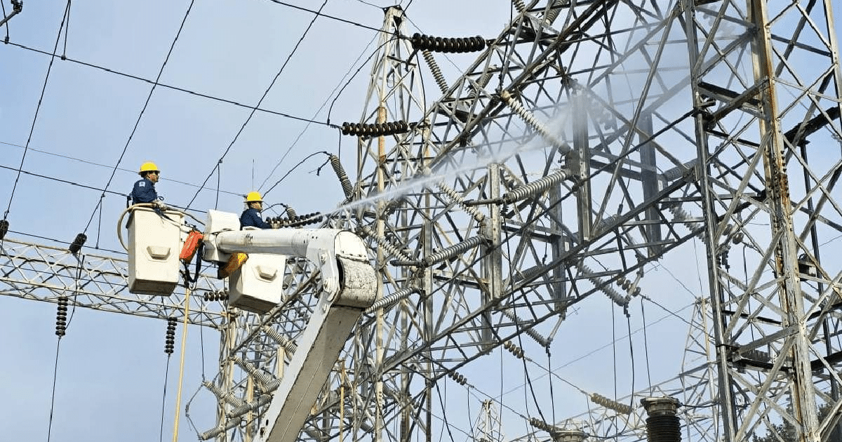 Trabajadores en grúa elevadora realizando mantenimiento en subestación eléctrica de Los Mochis.