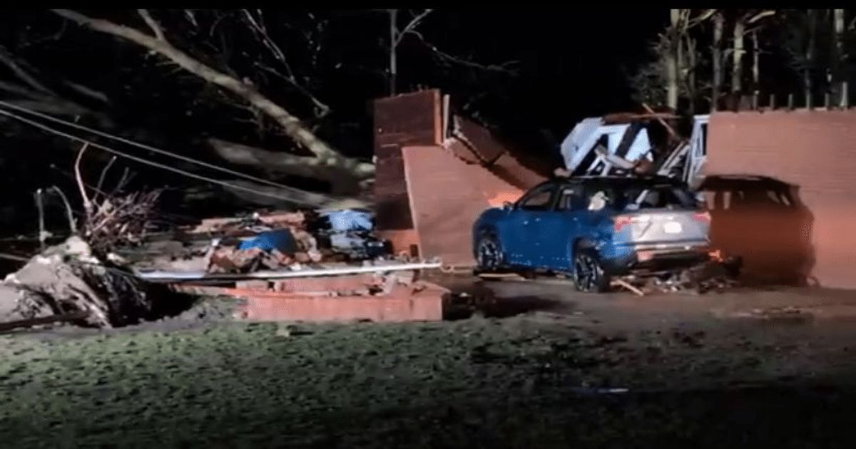 Vehículo azul entre escombros y árboles caídos tras un desastre natural en EE.UU.