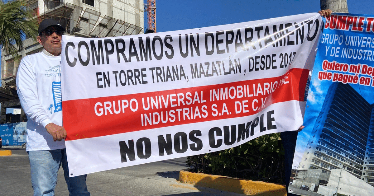 Hombre con pancarta de protesta frente a construcción de Torre Triana en Mazatlán