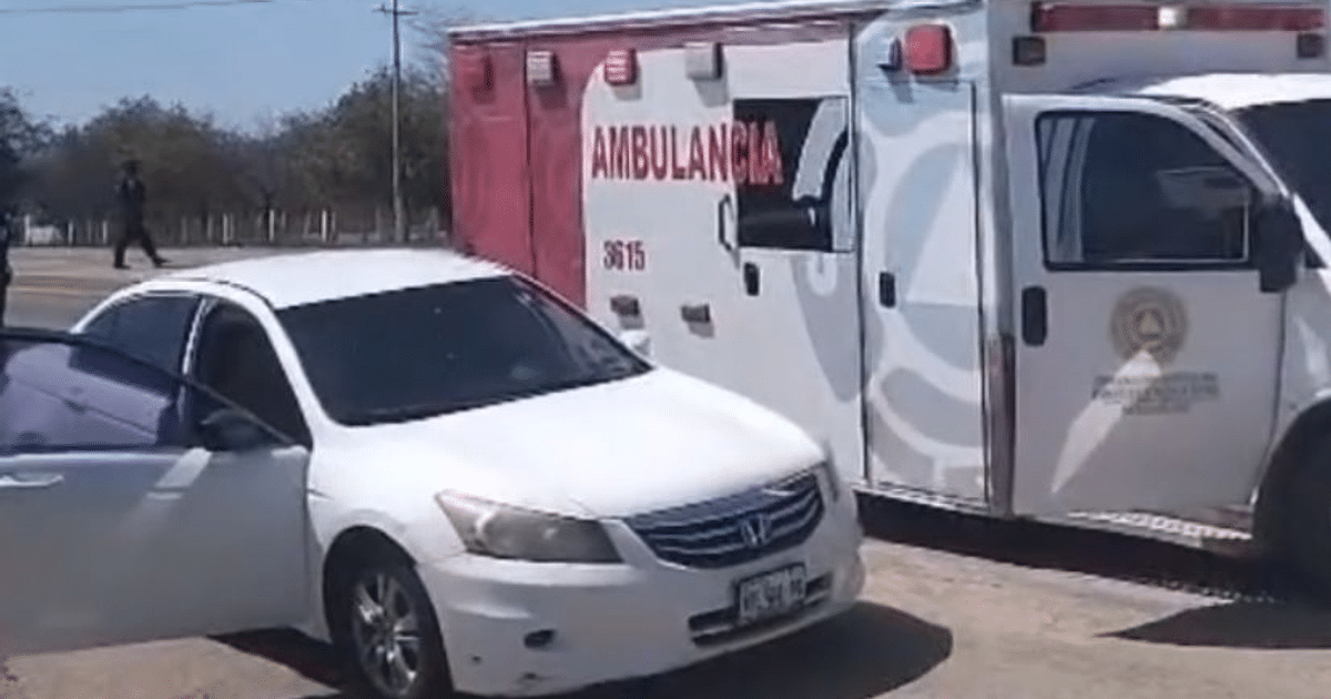 Automóvil blanco con puerta abierta junto a ambulancia en carretera México 15, escena de emergencia.