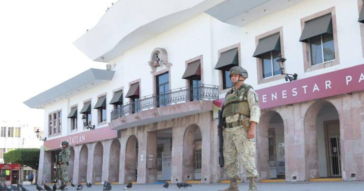 Soldado en uniforme militar frente a edificio urbano en Mazatlán, relacionado con hallazgo de explosivos.