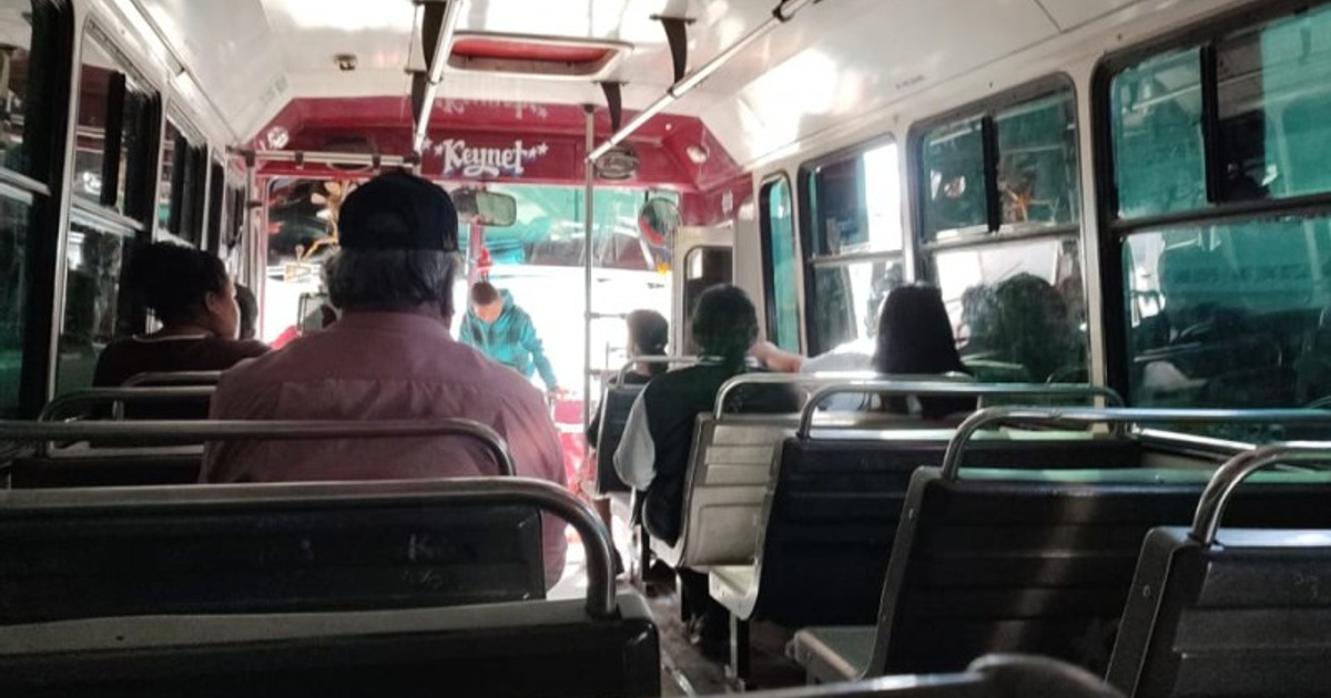 Interior de autobús con pasajeros y conductor en colores rojos y verdes