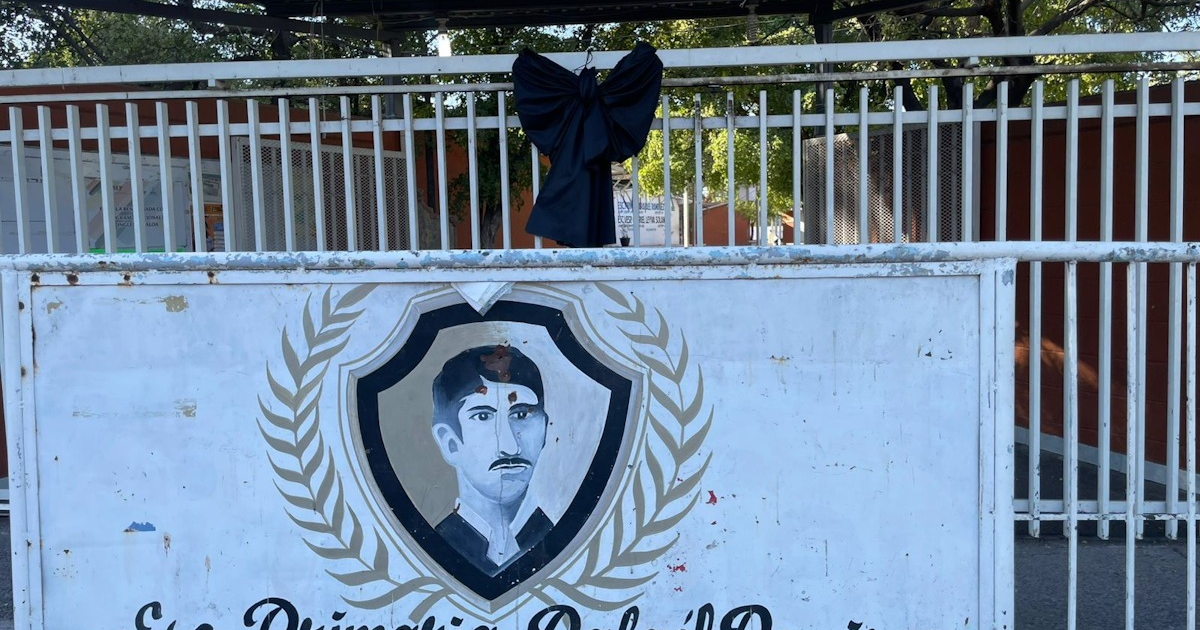 Cartel con retrato y moño negro en la escuela Rafael Ramírez