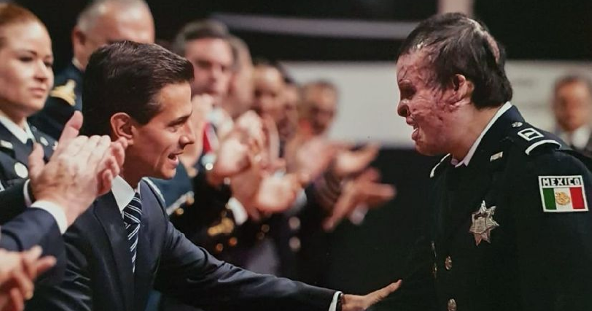 Iván Morales Corrales siendo reconocido en un evento público, rodeado de aplausos.