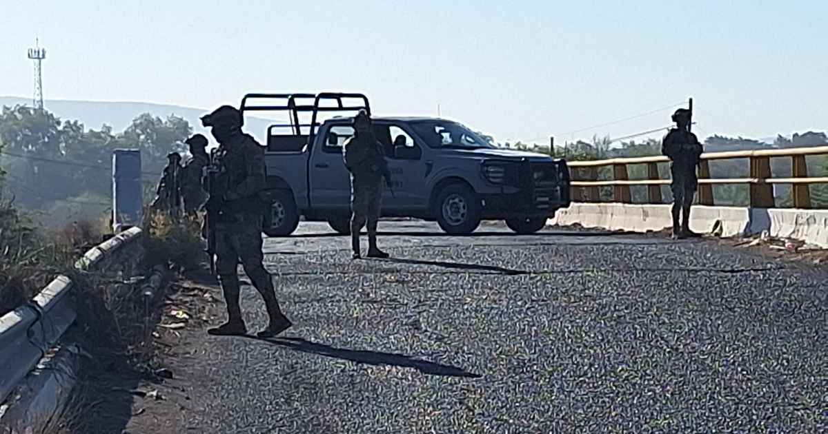 Soldados y agentes de seguridad en un camino rural de Culiacán junto a una camioneta.