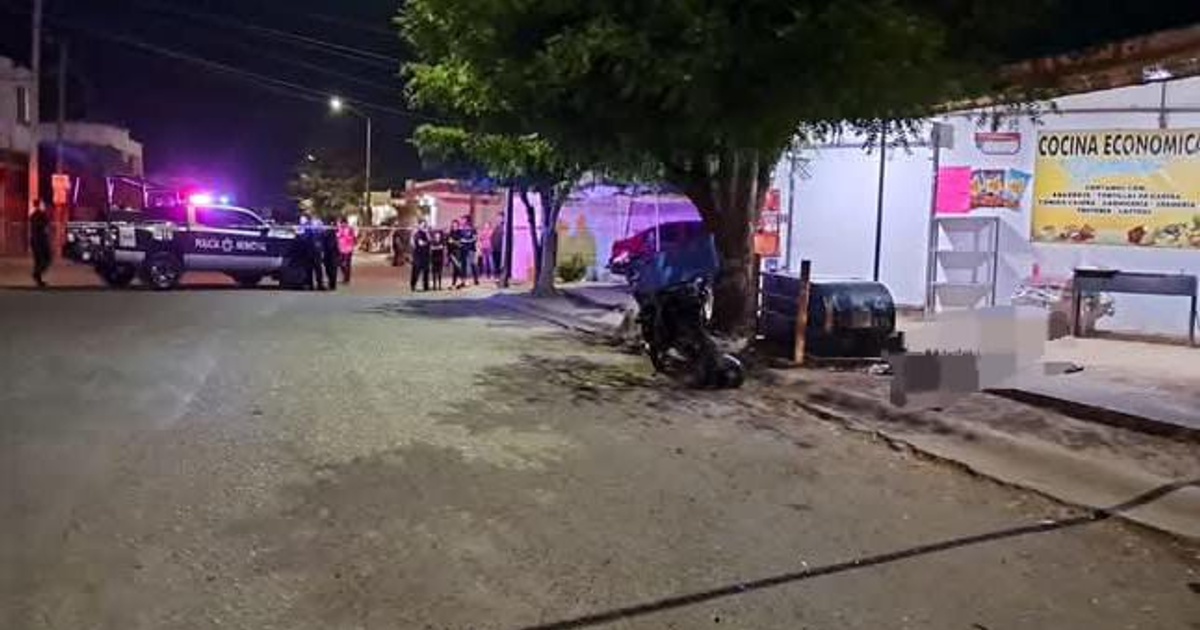 Escena nocturna con presencia policial en Culiacán, vehículo de policía, oficiales, y un establecimiento de comida al fondo.