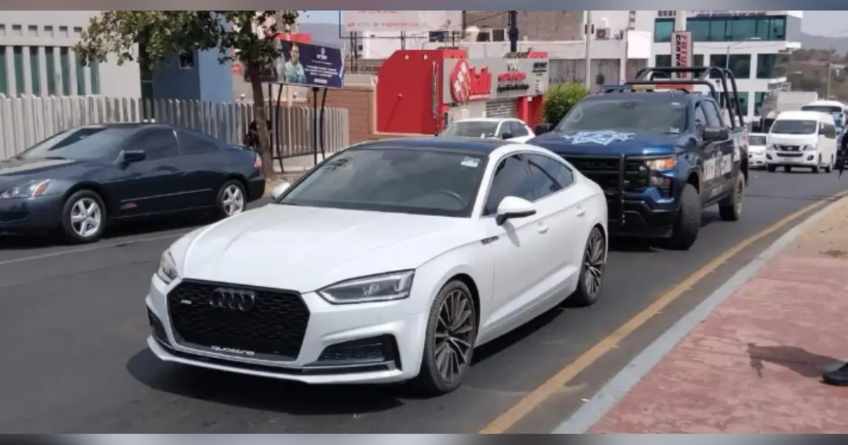 Calle con tráfico y un Audi S blanco abandonado en Montebello, Culiacán.