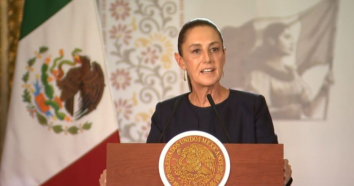 Mujer dando discurso oficial con bandera de México de fondo