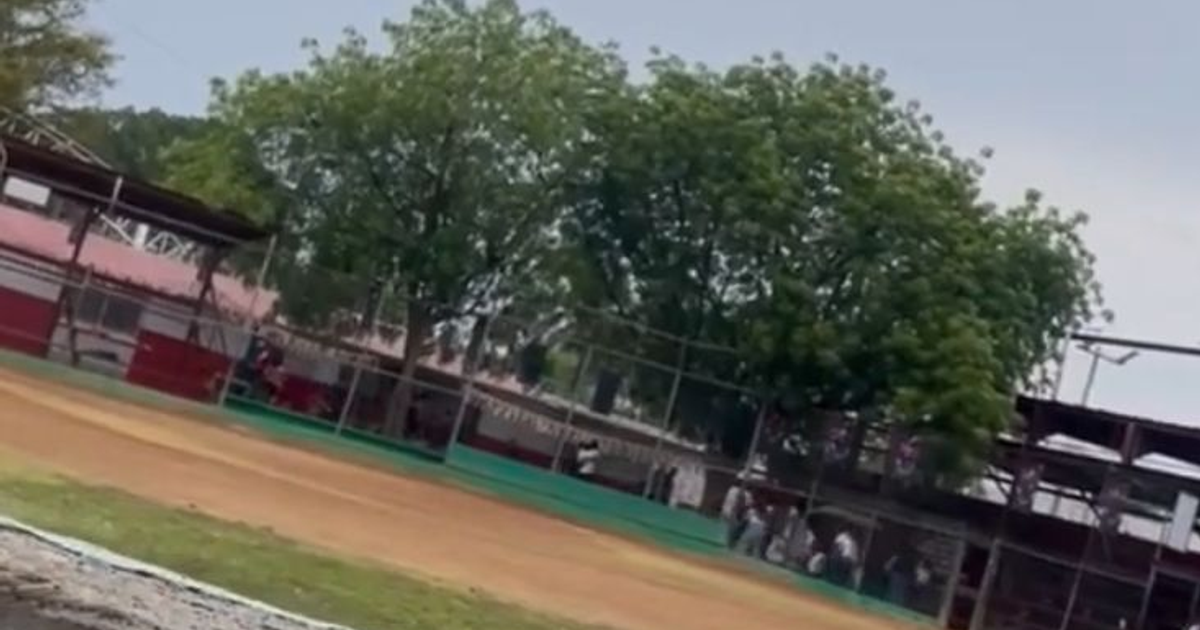 Campo de béisbol en Infonavit Humaya durante un tiroteo en un partido infantil, con personas presentes y un cielo nublado.