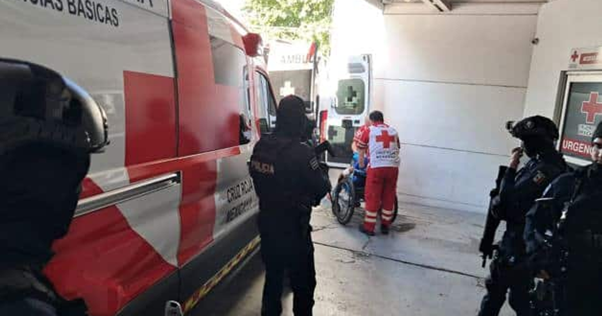 Paramédico de la Cruz Roja asistiendo a una persona en silla de ruedas en una escena de emergencia en Culiacán, con presencia policial.